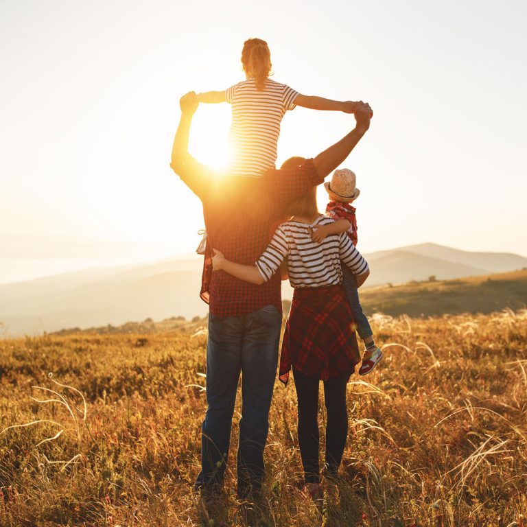 Photo carré d'une famille regardant le couché de soleil